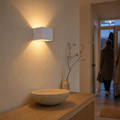 White Cube wall light automatically illuminates a hallway without visible wiring